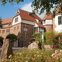 Das Bild zeigt das Rathaus von Reichelsheim mit Blumen im Vordergrund