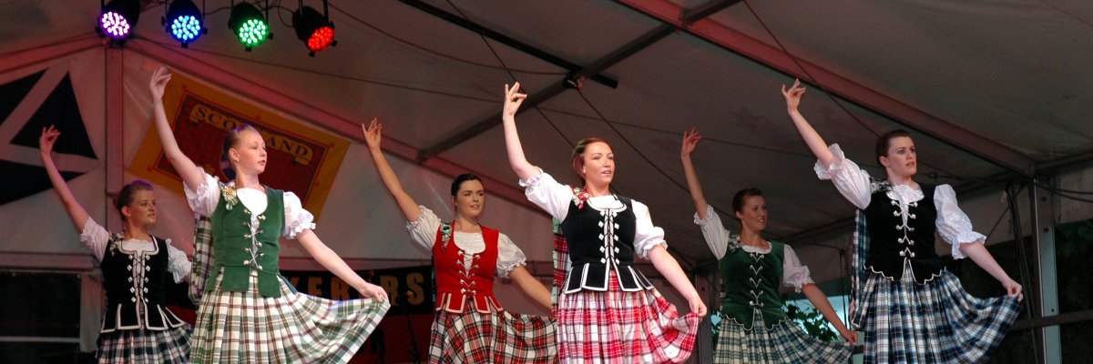 Das Bild zeigt Mädchen in schottischer Tracht beim Tanzen