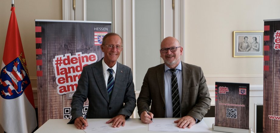 Das Foto zeigt den Chef der Hessischen Staatskanzlei, Axel Wintermeyer, und Landrat Frank Matiaske, die in Wiesbaden den Vertrag für das neue Koordinierungsentrum für Bürgerengagement unterschreiben.
