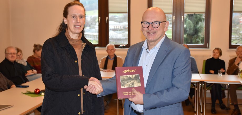 DAs Foto zeigt, wie Landrat Matiaske der Lektorin Schmidt-Herrmann ein neues "gelurt" überreicht.