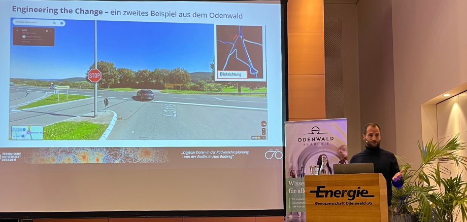 Das Foto zeigt den Vortragenden Dr.-Ing. Sven Lißner und an der Leinwand ein Radwege-Beispiel aus Oberzent.