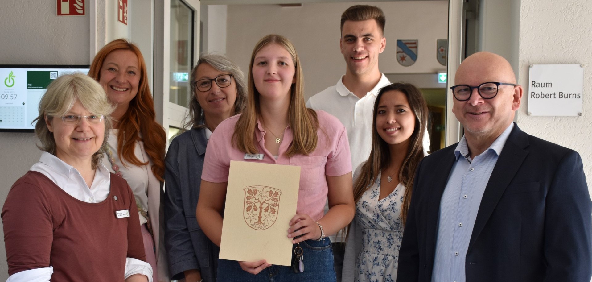 Das Foto zeigt Jule Schnauber mit Landrat Matiaske und Mitarbeitenden, die ihr zum Studienabschluss gratulieren.