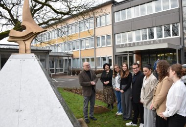 Landrat Matiaske erläutert Auszubildenden die Pyramide des Perseus vor dem Landratsamt.