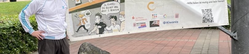 Das Foto zeigt Tobias Steiner, Schwimmeister im Freibad Reichelsheim, vor einem Aktions-Banner.