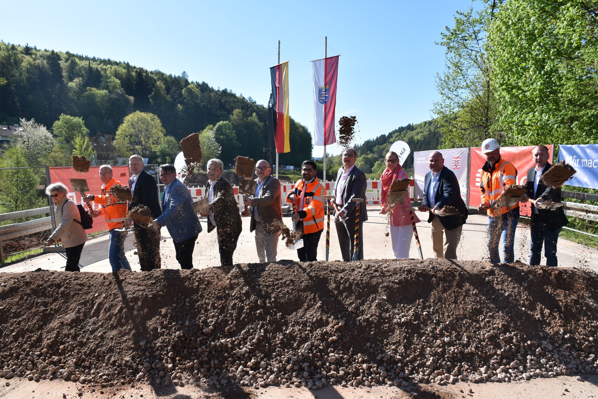 Das Foto zeigt mehrere Personen beim Spatenstich zum Bau der Zeller Brücke.