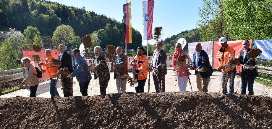 Das Foto zeigt mehrere Personen beim Spatenstich zum Bau der Zeller Brücke.