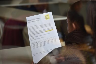 Eine Schülerin hält ein Blatt mit einer Umfrage zum Schulmobilitätsplan in der Hand.