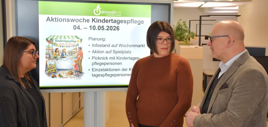 Landrat Matiaske im Gespräch mit Jugendamtsleiterin Glabisch und Mitarbeiterin Berg über Planungen zur Aktionswoche Kindertagespflege (Präsentation auf Monitor)