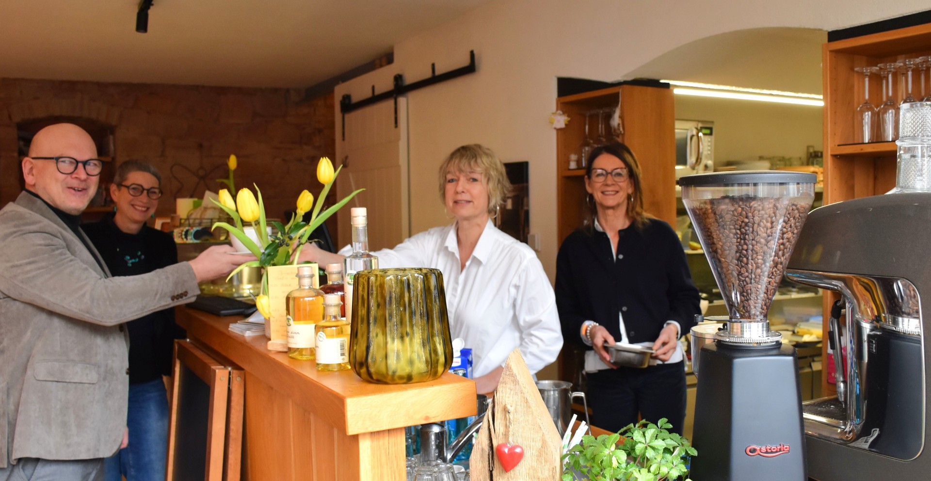 Landrat Frank Matiaske und Brigitte Lachnit, Leiterin der Abteilung Dorf- und Regionalentwicklung, besuchen das Café Endlich in Bad König. Betrieben wird es von Gabriele Carnier, die dem Landrat eine Tasse Kaffee reicht, und Sabine Grewing. 