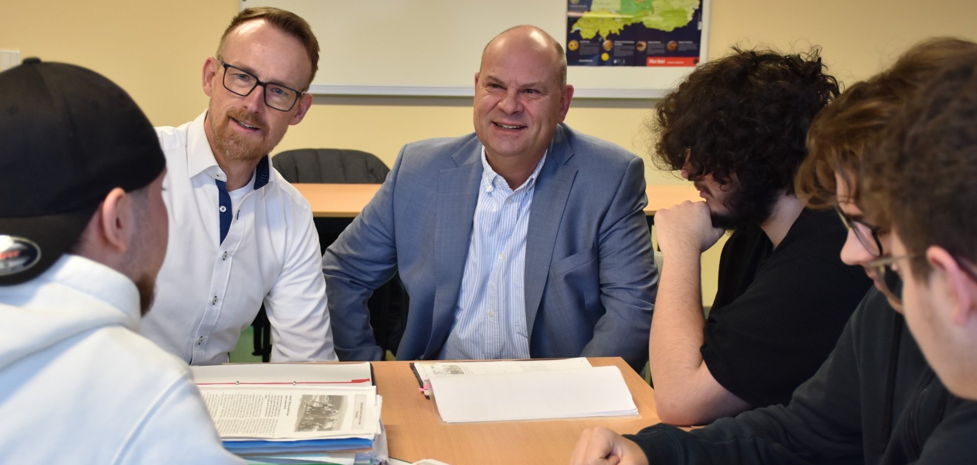 Teilnehmende eines Realschulkurses der VHS im Gespräch mit dem Ersten Kreisbeigeordneten Oliver Grobeis und VHS-Leiter Markus Dörr in der Theodor-Litt-Schule in Michelstadt