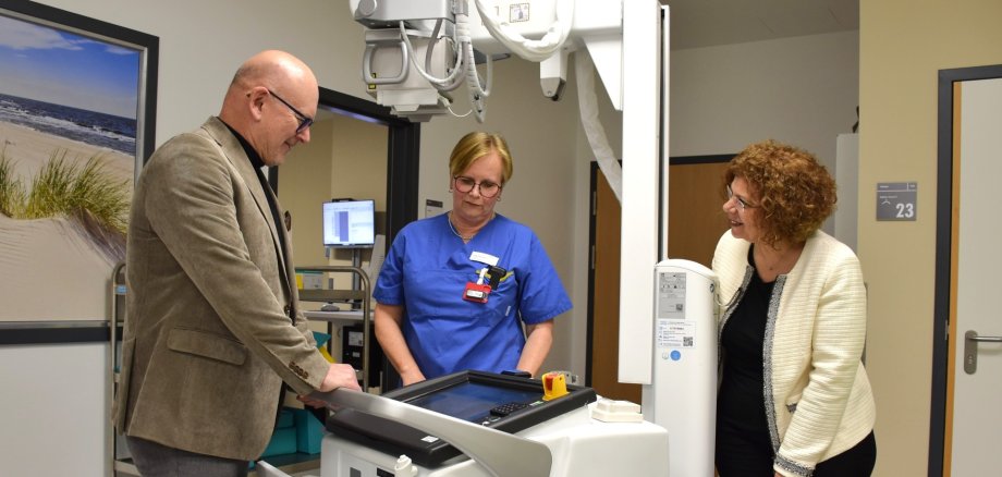 Landrat Matiaske und Krankenhaus-Geschäftsführerin Giacaman an einem mobilen Röntgengerät, dass ihnen von der Leiterin der Röntgenabteilung, Hammann, erklärt wird