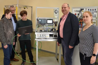 Zwei Schüler mit Laptop in der Smart Factory des BSO. Ihnen schauen zu: Lehrerin Silke Klar, Bildungsdezernent Oliver Grobeis, Schulleiter Horst Schad