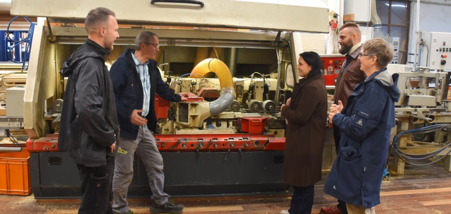 Vertreter des KJC beim Rundgang im Sägewerk Scior, Inhaber Wolfgang Scior erklärt eine große Hobelmaschine.